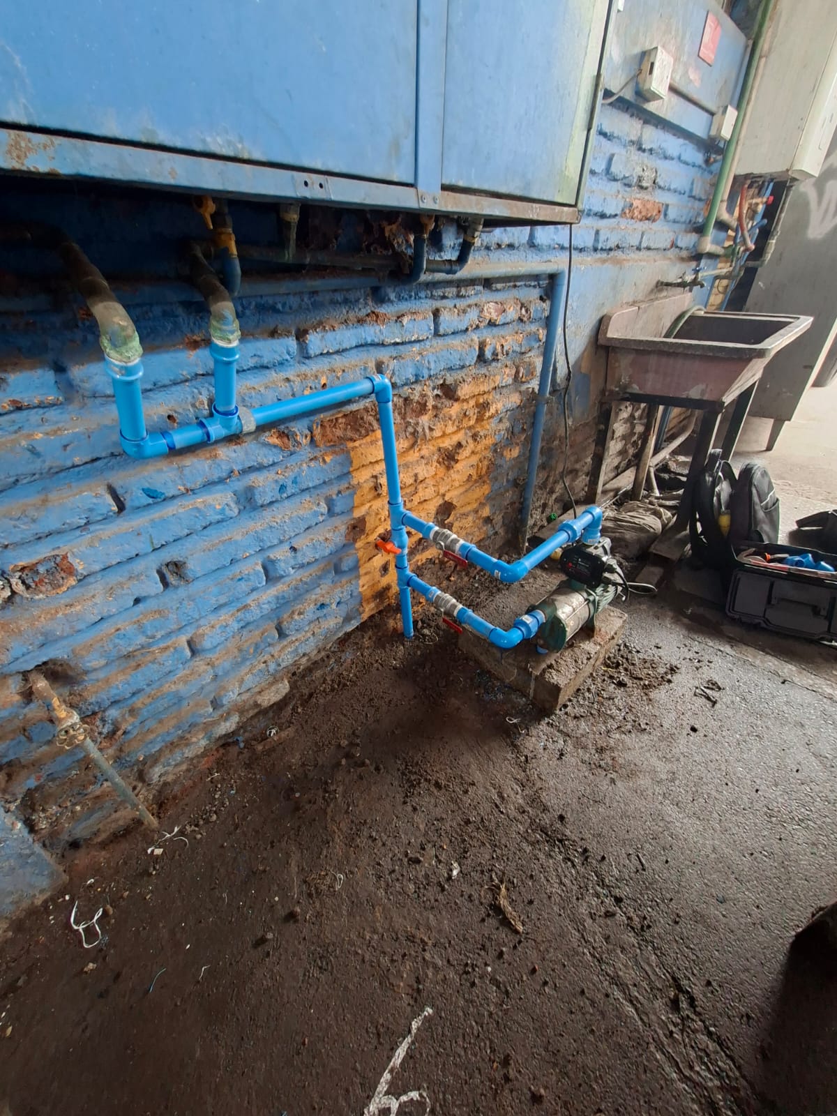 Bomba de agua con cañerías azules y válvulas