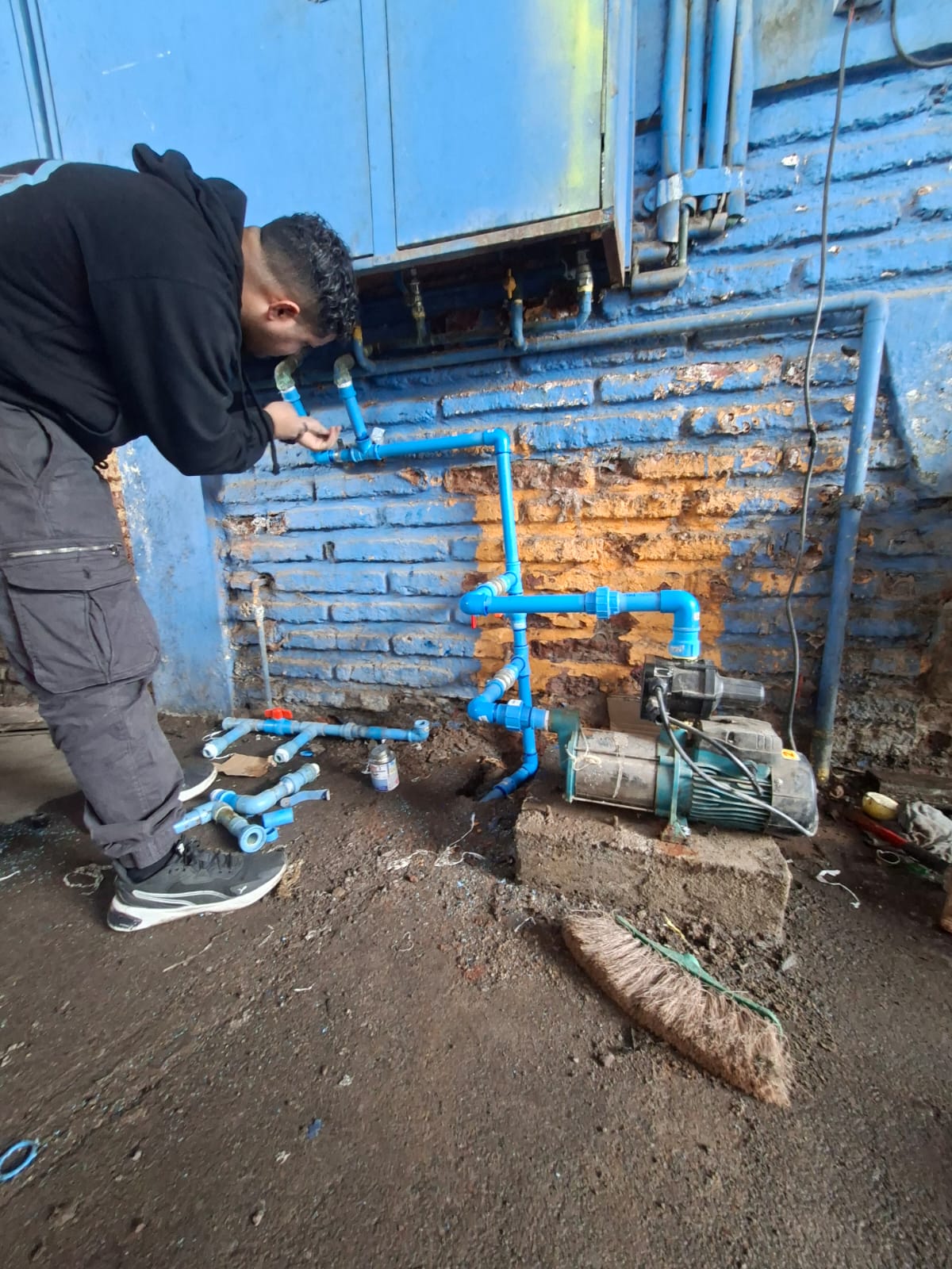Técnico trabajando en la red de cañerías junto a la bomba